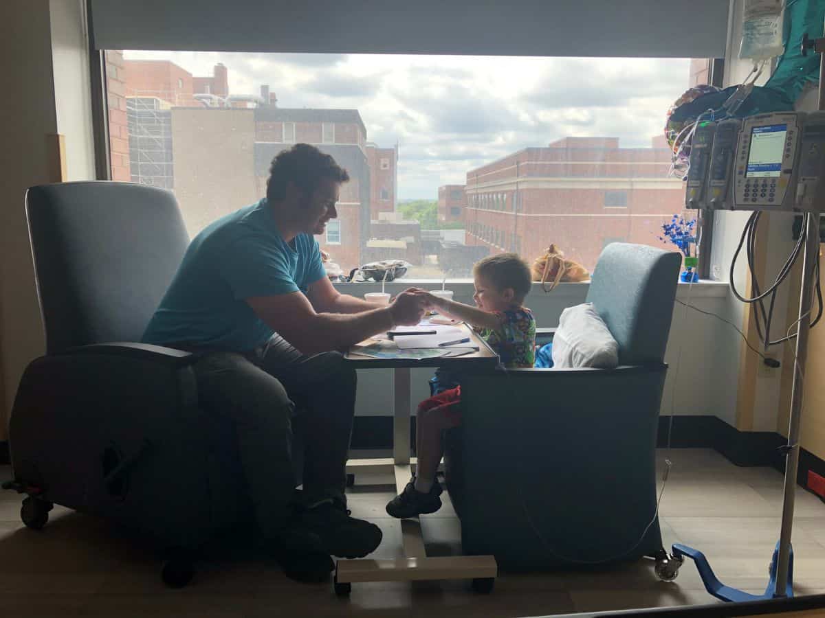 a son and father in the hospital holding hands