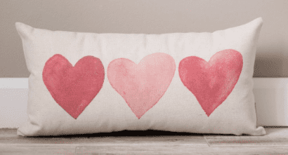 a throw pillow with three hearts on it