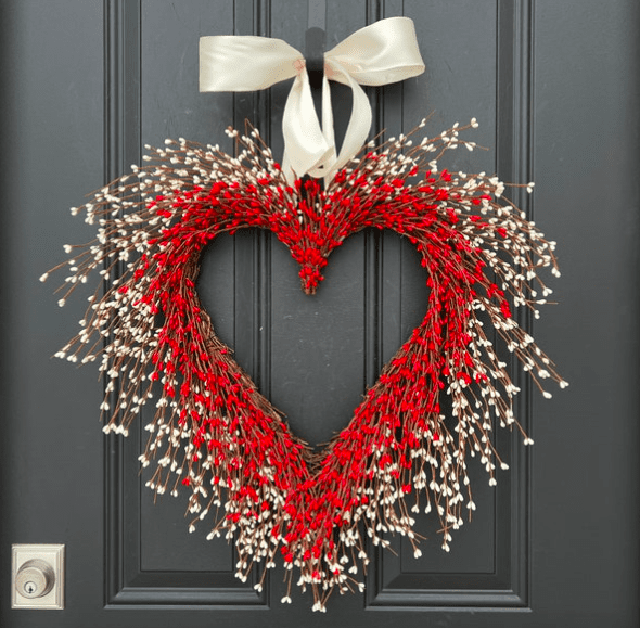 a heart shaped wreath hanging on a door
