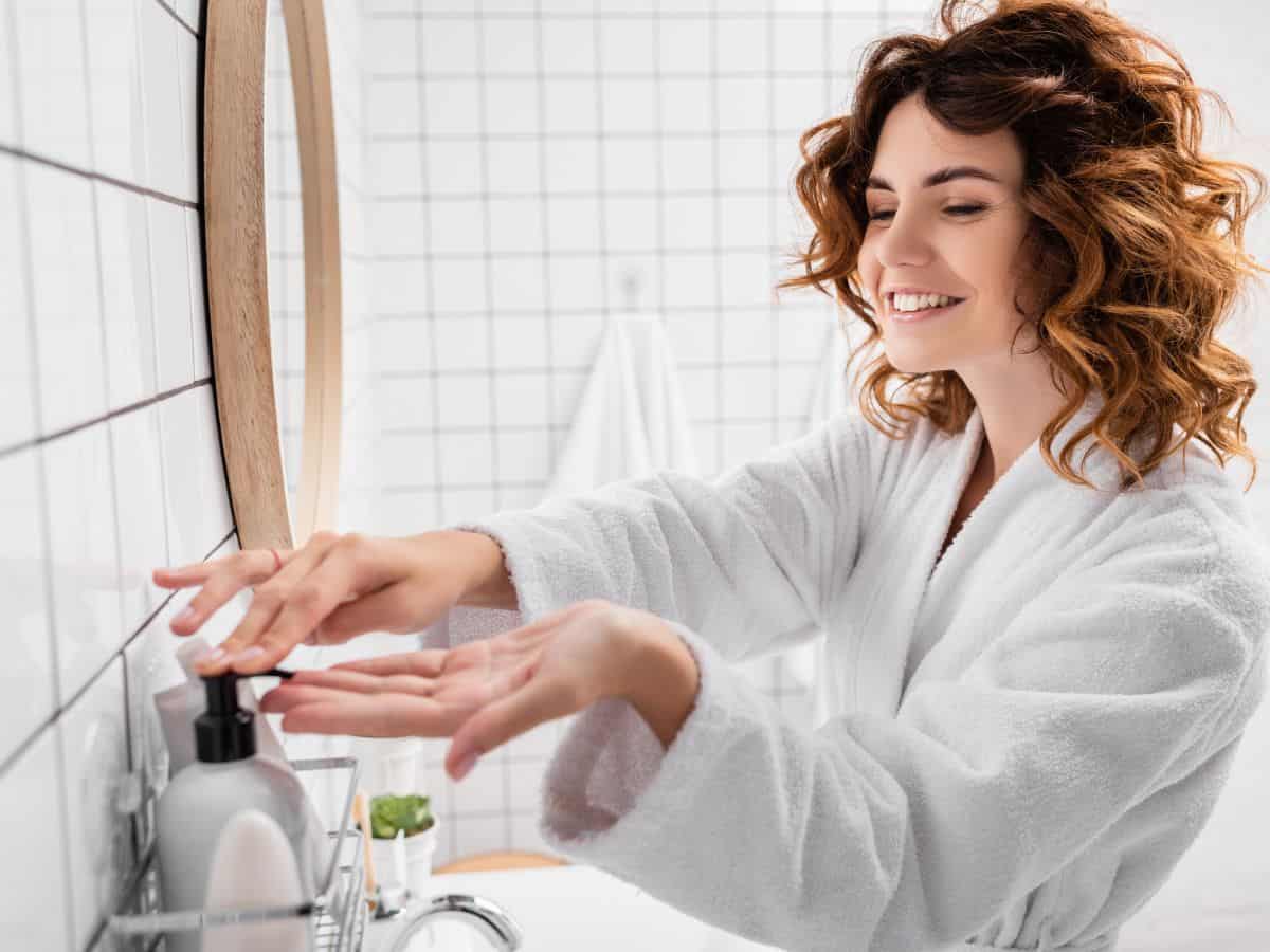 a woman with curly hair getting some product on her hand