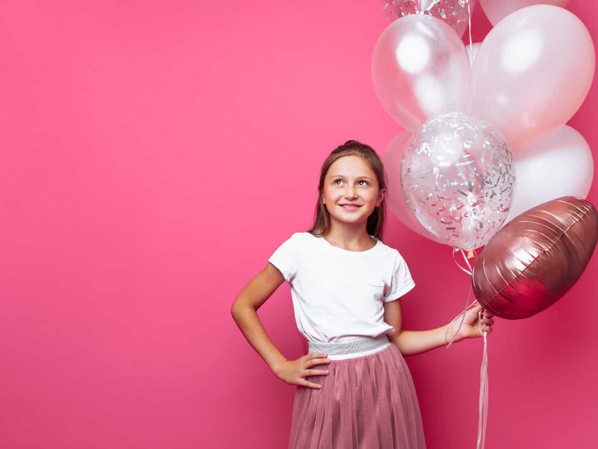 a girl with pink and red balloons