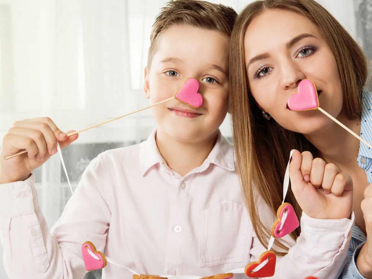 a mom and her son holding up valentine's day treats