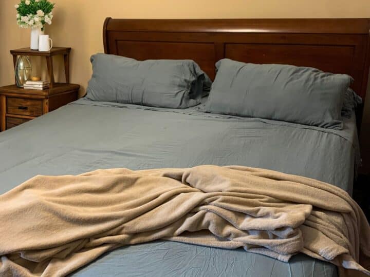 a bedroom with blue bamboo sheets and a blanket