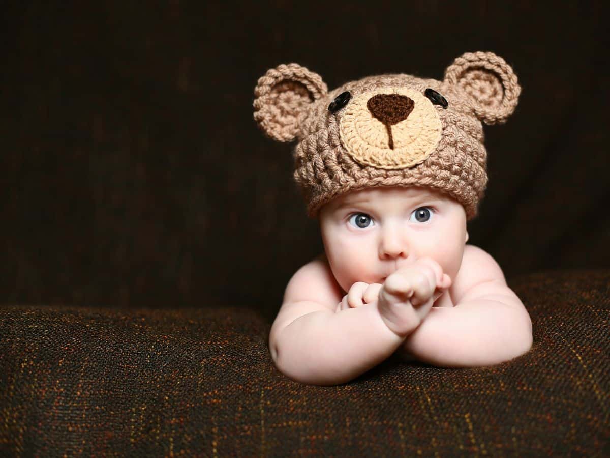 a baby boy with a crochet bear hat