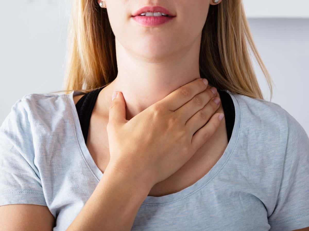 a woman with her hand on her neck