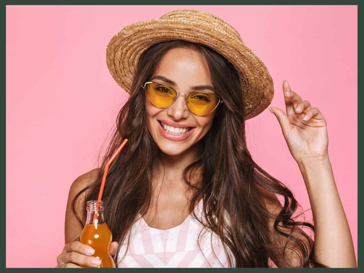 a woman holding a bottle of soda with a straw