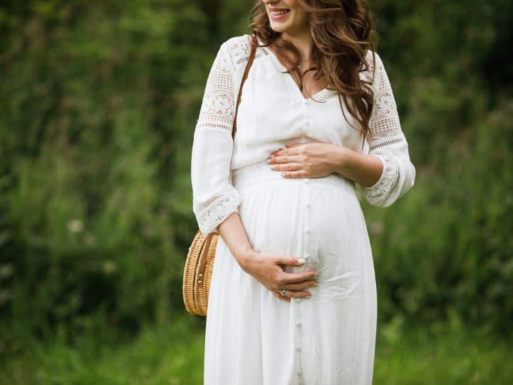 a pregnant woman with her hands resting on her growing bump